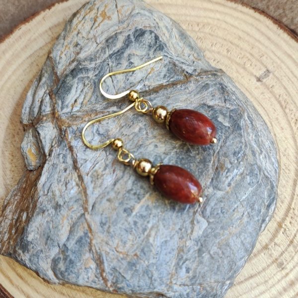 Aros dorados con piedras naturales rojas elegantes